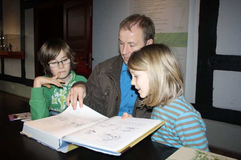Bei der abschließenden Vorleserunde machen die Jungs auch noch Bekanntschaft mit "Affe Fipps". (3 boys learning new stories of Wilhelm Busch.)